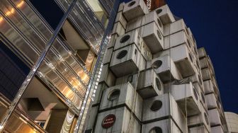 Pemandangan Menara Kapsul Nakagin yang terkenal di distrik Ginza, Tokyo, Jepang, Rabu (6/4/2022). [Philip FONG / AFP]