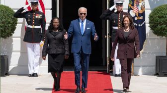 Presiden Amerika Serikat Joe Biden (tengah) berjalan keluar dari Gedung Putih bersama Wakil Presiden Kamala Harris (kanan) dan Hakim Ketanji Brown Jackson (kiri) saat acara pengukuhan Jackson menjadi Hakim Agung Amerika Serikat di Gedung Putih, Washington DC, Amerika Serikat, Jumat (8/4/2022). [Jim WATSON / AFP]