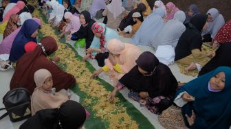 Umat Islam menggelar makan bersama atau megibung saat berbuka puasa di Masjid Baitul Makmur, Denpasar, Bali, Jumat (8/4/2022). [ANTARA FOTO/Nyoman Hendra Wibowo/wsj]