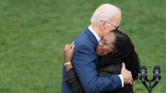 Presiden Amerika Serikat Joe Biden memeluk Hakim Ketanji Brown Jackson saat acara pengukuhan Jackson menjadi Hakim Agung Amerika Serikat di Gedung Putih, Washington DC, Amerika Serikat, Jumat (8/4/2022). [Jim WATSON / AFP]