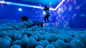 Orang-orang mengunjungi ruangan "You Underwater" di dalam Youseum di Solna, Stockholm, Swedia, Senin (4/4/2022). [Jonathan NACKSTRAND / AFP]