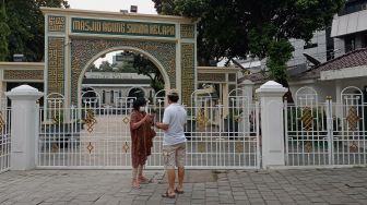 Warga berdiri di depan Masjid Agung Sunda Kelapa, Menteng, Jakarta, Minggu (10/4/2022). [Suara.com/Angga Budhiyanto]