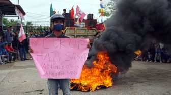 Mahasiswa membawa kertas bertuliskan protes terhadap kebijakan pemerintah pusat di halaman kantor DPRD Kota Sorong, Papua Barat, Senin (11/4/2022). [Antara Foto]
