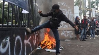 Massa aksi menendang gerbang saat melakukan unjuk rasa di depan gedung DPR RI, Jakarta, Senin (11/4/2022). [Suara.com/Angga Budhiyanto]