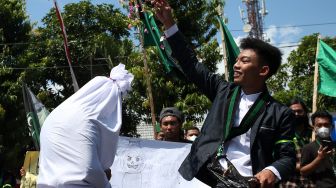 Mahasiswa melakukan aksi teatrikal di depan kantor DPRD Kota Blitar, Jawa Timur, Senin (11/4/2022). ANTARA FOTO/Irfan Anshori
