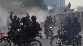 Polisi membubarkan massa aksi saat unjuk rasa di sekitar gedung DPR RI, Jakarta, Senin (11/4/2022). [Suara.com/Angga Budhiyanto]