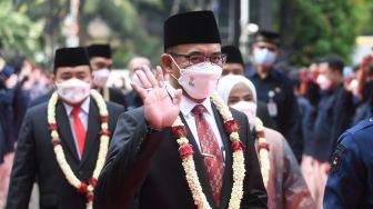 Komisioner Komisi Pemilihan Umum (KPU) periode 2022-2027 Hasyim Asy'ari melambaikan tangan setibanya di Gedung KPU, Jakarta, Selasa (12/4/2022). ANTARA FOTO/Akbar Nugroho Gumay
