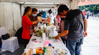 Pengunjung membeli makanan di acara Festival Kuliner Nusantara di Taman Ismail Marzuki (TIM), Cikini, Jakarta Pusat, Rabu (13/4/2022). [Suara.com/Alfian Winanto]