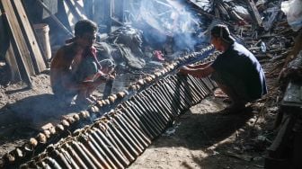 Pekerja menyelesaikan pembuatan lemang bambu di Kramat Raya, Senen, Jakarta Pusat, Rabu (13/4/2022). [Suara.com/Alfian Winanto]