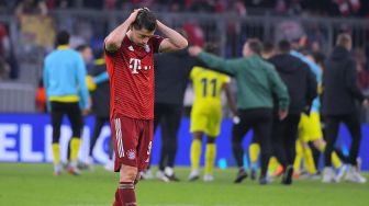 Pemain depan Bayern Munich Robert Lewandowski berjalan lemas setelah pertandingan sepak bola leg kedua Bayern Munich melawan Villarreal di Allianz Arena, Rabu dinihari WIB (13/4/2022).  Jose Jordan / AFP