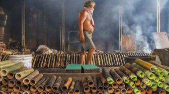 Pekerja menyelesaikan pembuatan lemang bambu di Kramat Raya, Senen, Jakarta Pusat, Rabu (13/4/2022). [Suara.com/Alfian Winanto]