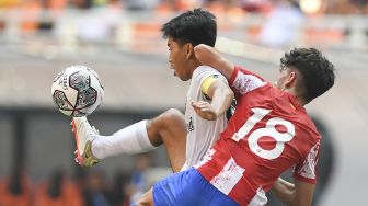 Pesepak bola Atletico Madrid U-18 Jacobo De Oro Lorenzo (kanan) berusaha merebut bola dari pesepak bola Bali United U-18 I Made Tito Wiratawa pada pertandingan International Youth Championship (IYC) 2021 di Jakarta International Stadium. Jakarta, Rabu (13/4/2022). ANTARA FOTO/Hafidz Mubarak
