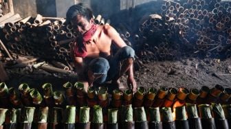 Pekerja menyelesaikan pembuatan lemang bambu di Kramat Raya, Senen, Jakarta Pusat, Rabu (13/4/2022). [Suara.com/Alfian Winanto]