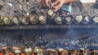 Pekerja menyelesaikan pembuatan lemang bambu di Kramat Raya, Senen, Jakarta Pusat, Rabu (13/4/2022). [Suara.com/Alfian Winanto]