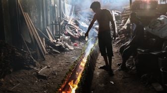 Pekerja menyelesaikan pembuatan lemang bambu di Kramat Raya, Senen, Jakarta Pusat, Rabu (13/4/2022). [Suara.com/Alfian Winanto]