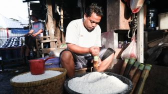 Pekerja menyelesaikan pembuatan lemang bambu di Kramat Raya, Senen, Jakarta Pusat, Rabu (13/4/2022). [Suara.com/Alfian Winanto]