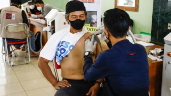 Petugas menghapus tato peserta saat program hapus tato di Masjid Assahara, Kembangan, Jakarta Barat, Rabu (13/4/2022). [Suara.com/Alfian Winanto]