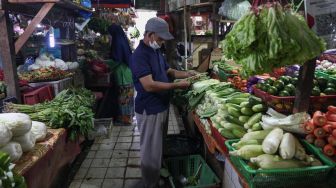 Pedagang memotong daging sapi di Pasar PSPT Tebet, Jakarta Selatan, Kamis (14/4/2022). [Suara.com/Alfian Winanto]