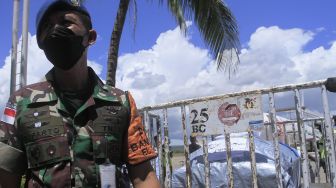 Seorang anggkota TNI AU mengawasi proses pengakutan peti mati berisi jenazah korban kecelakaan maut di Papua Barat tiba di bandara El Tari Kupang, NTT, Kamis (14/4/2022). ANTARA FOTO/Kornelis Kaha