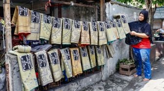 Pengrajin menjemur sajadah yang sudah di sablon di Kawasan Kebon Melati, Tanah Abang, Jakarta Pusat, Kamis (14/4/2022). [Suara.com/Alfian Winanto]