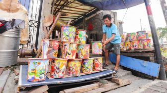 Penjual menyusun bedug dagangannya di Jalan KH Mas Mansyur, Tanah Abang, Jakarta Pusat, Jumat (15/4/2022). [Suara.com/Alfian Winanto]