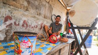 Penjual menyelesaikan pembuatan bedug di Jalan KH Mas Mansyur, Tanah Abang, Jakarta Pusat, Jumat (15/4/2022). [Suara.com/Alfian Winanto] ya