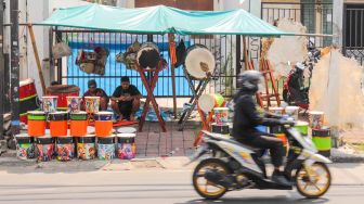 Penjual bedug menunggu pembeli di Jalan KH Mas Mansyur, Tanah Abang, Jakarta Pusat, Jumat (15/4/2022). [Suara.com/Alfian Winanto]