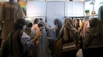 Pengunjung memilih busana muslim di area bazaar pakaian saat gelaran Indonesia Fashion Week 2022, Jakarta Convention Center (JCC), Jakarta, Jumat (15/4/2022). [Suara.com/Angga Budhiyanto]