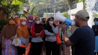 Sejumlah warga mengantre untuk mendapatkan sayuran dan pakaian bekas layak pakai yang dijajakan secara gratis di Jalan Jati Padang VI RT 002 RW 004, Pasar Minggu, Jakarta, Minggu (17/4/2022). [Suara.com/Angga Budhiyanto]