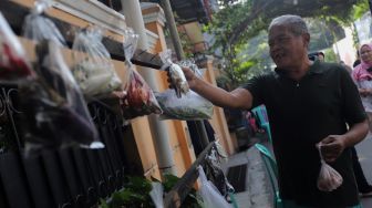 Warga memilah sayuran yang dijajakan secara gratis di Jalan Jati Padang VI RT 002 RW 004, Pasar Minggu, Jakarta, Minggu (17/4/2022). [Suara.com/Angga Budhiyanto]