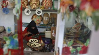 Perajin menyelesaikan lukisan kaligrafi Arab pada piring keramik di rumah produksi Fairus Art, Desa Plumbon, Sukoharjo, Jawa Tengah, Sabtu (16/4/2021). [ANTARAFOTO/Maulana Surya/rwa]
