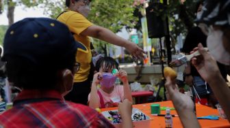 Peserta mengikuti lomba melukis telur di Lapangan Banteng, Jakarta, Minggu (17/4/2022). [Suara.com/Angga Budhiyanto]