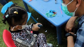 Peserta mengikuti lomba melukis telur di Lapangan Banteng, Jakarta, Minggu (17/4/2022). [Suara.com/Angga Budhiyanto]