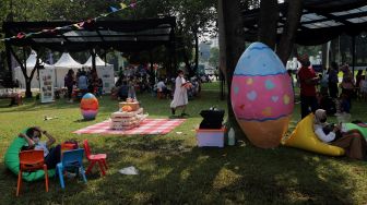 Pengunjung menikmati suasana Festival Telur 2022 di Lapangan Banteng, Jakarta, Minggu (17/4/2022). [Suara.com/Angga Budhiyanto]