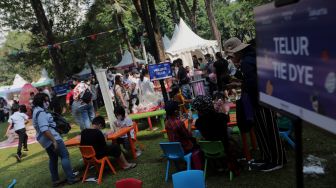 Peserta mengikuti lomba melukis telur di Lapangan Banteng, Jakarta, Minggu (17/4/2022). [Suara.com/Angga Budhiyanto]