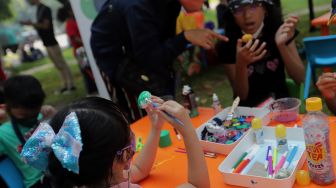 Peserta mengikuti lomba melukis telur di Lapangan Banteng, Jakarta, Minggu (17/4/2022). [Suara.com/Angga Budhiyanto]