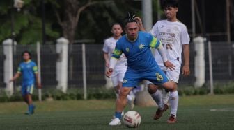 Pemain Selebritis FC Augie Fantinus berusaha melewati lawan saat mengikuti sesi latihan di Lapangan ABC, Kompleks Gelora Bung Karno, Jakarta, Senin (18/4/2022). [Suara.com/Angga Budhiyanto]