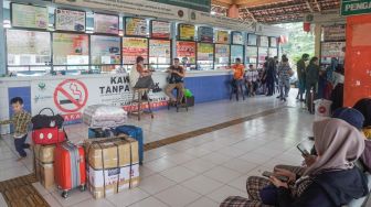 Calon pemudik menunggu di Kampung Rambutan, Jakarta Timur, Senin (18/4/2022). [Suara.com/Alfian Winanto]