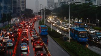 Sejumlah kendaraan terjebak kemacetan di kawasan Sudirman, Jakarta Pusat, Selasa (19/4/2022). [Suara.com/Alfian Winanto]
