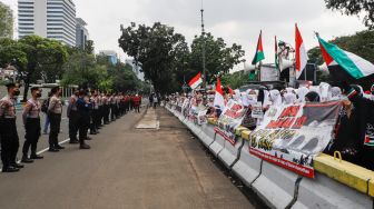 Sejumlah massa dari lembaga kemanusiaan Aqsa Working Group (AWG) saat menggelar aksi Bela Al-Aqsa di depan Kedutaan Besar Amerika di Jalan Medan Merdeka Selatan, Jakarta Pusat, Rabu (20/4/2022). [Suara.com/Alfian Winanto]