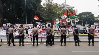 Sejumlah massa dari lembaga kemanusiaan Aqsa Working Group (AWG) saat menggelar aksi Bela Al-Aqsa di depan Kedutaan Besar Amerika di Jalan Medan Merdeka Selatan, Jakarta Pusat, Rabu (20/4/2022). [Suara.com/Alfian Winanto]