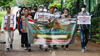 Sejumlah massa dari lembaga kemanusiaan Aqsa Working Group (AWG) saat menggelar aksi Bela Al-Aqsa di depan Kedutaan Besar Amerika di Jalan Medan Merdeka Selatan, Jakarta Pusat, Rabu (20/4/2022). [Suara.com/Alfian Winanto]