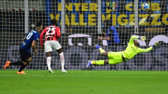 Penyerang Inter Milan Lautaro Martinez (kiri) mencetak gol pembuka melewati kiper AC Milan Mike Maignan (kanan) pada pertandingan semifinal Piala Italia (Coppa Italia), leg kedua antara Inter melawan AC Milan di Stadion Giuseppe Meazza, Rabu (20/4) dini hari WIB.  MIGUEL MEDINA / AFP