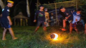 Seorang warga melakukan atraksi api pada acara Purnacandra di Kampung Batara, Papring Kalipuro, Banyuwangi, Jawa Timur, Rabu (20/4/2022) malam.  ANTARA FOTO/Budi Candra Setya