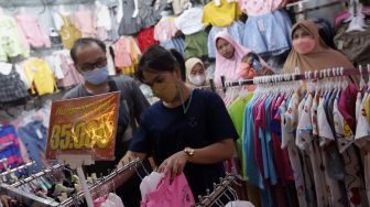 Pengunjung memilih pakaian di Pasar Tanah Abang, Jakarta, Sabtu (23/4/2022). [Suara.com/Angga Budhiyanto]