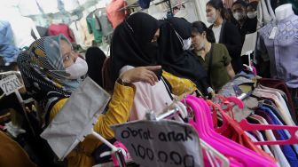 Pengunjung memilih pakaian di Pasar Tanah Abang, Jakarta, Sabtu (23/4/2022). [Suara.com/Angga Budhiyanto]