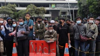 Warga mengantre untuk mendaftar mudik gratis angkutan Lebaran di Polda Metro Jaya, Jakarta, Sabtu (23/4/2022). [Suara.com/Angga Budhiyanto] 