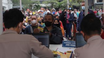 Polisi memberikan tiket mudik gratis angkutan Lebaran kepada warga di Polda Metro Jaya, Jakarta, Sabtu (23/4/2022). [Suara.com/Angga Budhiyanto]