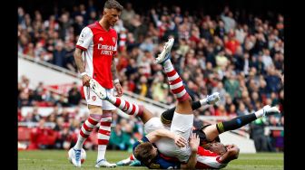 Bek Arsenal Ben White (kiri) melihat gelandang Manchester United Scott McTominay (tengah) berselisih dengan bek Arsenal Gabriel (kanan) saat pertandingan sepak bola Liga Premier Inggris antara Arsenal dan Manchester United di Stadion Emirates, London, Inggris, Sabtu (23/4/2022). [Ian Kington / IKIMAGES / AFP]
