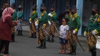 Pengunjung berfoto dengan prajurit Keraton Kasunanan Surakarta Hadiningrat saat acara atraksi hiburan di Solo, Jawa Tengah, Sabtu (23/4/2022). [ANTARAFOTO/Maulana Surya/rwa]